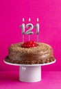 Number 121 candle - Chocolate cake on pink background