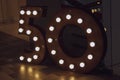 Number 50 carved from wood with bright bulbs around the perimeter. The concept of discounts and sales in stores, an important date Royalty Free Stock Photo