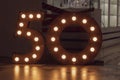 Number 50 carved from wood with bright bulbs around the perimeter. The concept of discounts and sales in stores, an important date Royalty Free Stock Photo