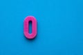 Number 0 color pink - Plastic piece on blue foamy background