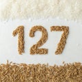 Number 127 created with different types of rice on a white background showcasing creativity and natural materials Royalty Free Stock Photo