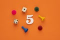 Number 5 with dice and board game pieces - Orange eva rubber background Royalty Free Stock Photo