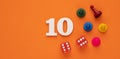 Number 10 with dice and board game pieces - Orange eva rubber background Royalty Free Stock Photo