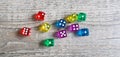 A number of dice in various colours rolled on a wooden floor Royalty Free Stock Photo