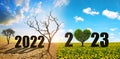 Number 2022 in dry country with cracked soil and 2023 in the dandelions field. Concept of Happy New Year.