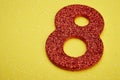 Number eight red color over a yellow background. Anniversary Royalty Free Stock Photo
