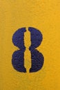 Number eight stenciled in black on yellow surface