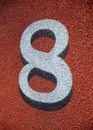 White number eight lane marker on red athletic track background