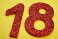 Number eighteen red color over a yellow background. Anniversary