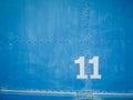 Number eleven in white with blue background and rivets Royalty Free Stock Photo
