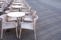 A number of empty tables with chairs are connected by a cable from theft in a cafe on the street Royalty Free Stock Photo