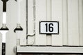 Number 16 on the facade of a baige house.. Royalty Free Stock Photo