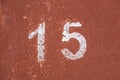The number fifteen in white on an old red wall Royalty Free Stock Photo