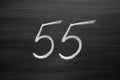 Number fifty five enumeration written with a chalk on the blackboard