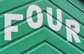 Number FOUR in letters written on the side of a wooden beach hut Royalty Free Stock Photo