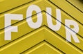 Number FOUR in letters written on the side of a wooden beach hut Royalty Free Stock Photo