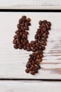 Number four made of coffee beans lying on white wood. Royalty Free Stock Photo
