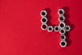 number four, made with steel nuts on red fabric background Royalty Free Stock Photo