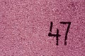 number fourty seven on pink plaster wall.