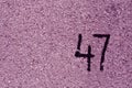 number fourty seven on purple plaster wall.