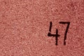 number fourty seven on red plaster wall.