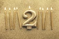 Number 2 gold celebration candle on a glitter background Royalty Free Stock Photo