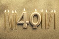 Number 40 gold celebration candle on a glitter background Royalty Free Stock Photo