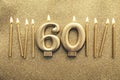 Number 60 gold celebration candle on a glitter background Royalty Free Stock Photo