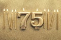 Number 75 gold celebration candle on a glitter background Royalty Free Stock Photo