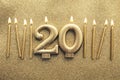 Number 20 gold celebration candle on a glitter background Royalty Free Stock Photo