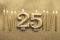 Number 25 gold celebration candle on a glitter background Royalty Free Stock Photo