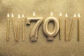 Number 70 gold celebration candle on a glitter background Royalty Free Stock Photo