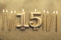 Number 15 gold celebration candle on a glitter background Royalty Free Stock Photo