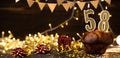 Number 58 golden festive burning candles in a cake, wooden holiday background. fifty-eight years since the birth. the Royalty Free Stock Photo