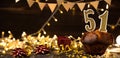 Number 51 golden festive burning candles in a cake, wooden holiday background. fifty-one years since the birth. the Royalty Free Stock Photo