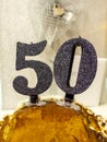 Number 50 happy birthday celebration candle. Candles on a homemade cake. Silver background Royalty Free Stock Photo