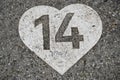 Number 14 in a heart painted on concrete