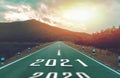 Number 2021 on highway road with high mountains and bright sunlight to Goals success. Concept New year 2021