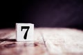 Number 7 isolated on dark background- 3D number seven isolated on vintage wooden table