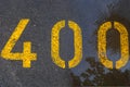 The number 400 is located on wet asphalt. Royalty Free Stock Photo