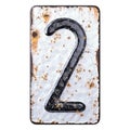 Number 2 made of forged metal on the background fragment of a metal surface with cracked rust.