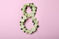 Number 8 made with white roses on pink background, flat lay. International Women`s day Royalty Free Stock Photo