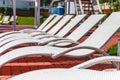 A number of many light loungers near the pool with a slide