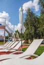 A number of many light loungers near the pool with a slide