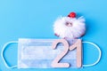 Number 21 on a medical protective mask and Santa Claus on a blue background. Christmas and New Year concept in coronavirus Royalty Free Stock Photo