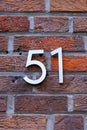 Number 51 metal house number on brick wall