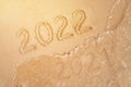 number of the new year written in sand, on tropical beach. Change numbers 2021 to 2022. New year holidays on a tropical island. Royalty Free Stock Photo