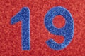 Number nineteen blue color over a red background. Anniversary. Royalty Free Stock Photo