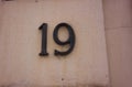 Number nineteen is made of metal, fastened with metal screws on the wall Royalty Free Stock Photo