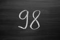 Number ninety eight enumeration written with a chalk on the blackboard